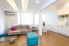 Sala de estar ampla, bem iluminada e confortável. Equipada com sofá, TV e mesa de jantar. 